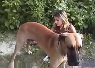 Tempting lady with a sexy body seducing a sexy dog while outdoors